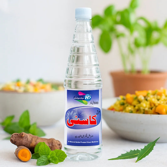 Hayat Dawakhana Arq e Kasni herbal water shown with turmeric mint and fresh greens in a clean natural wellness background.