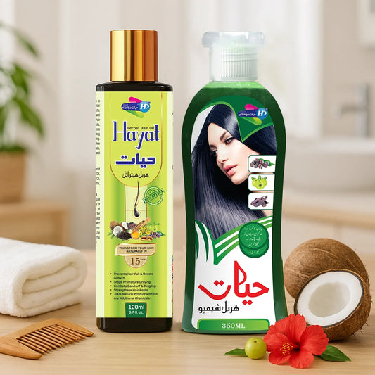 Hayat Herbal Shampoo and Hayat Herbal Hair Oil bundle placed with coconut, hibiscus flower and amla on a wooden surface.