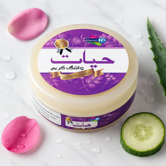 Hayat Whitening Cream closed jar with cucumber slice, aloe vera leaf and rose petals on marble surface.