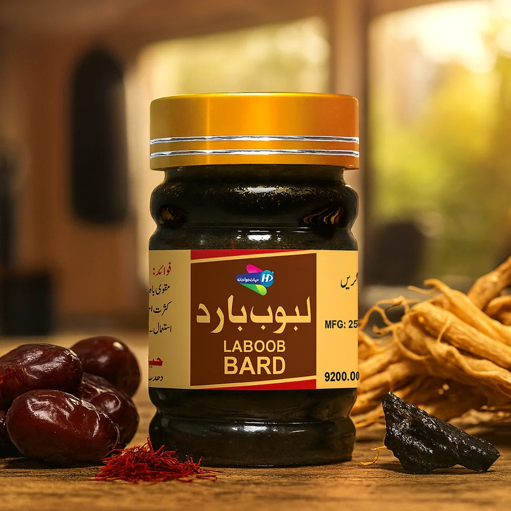 Laboob Bard herbal jam jar placed on a wooden table with dates, saffron, ginseng roots, and a blurred indoor background.