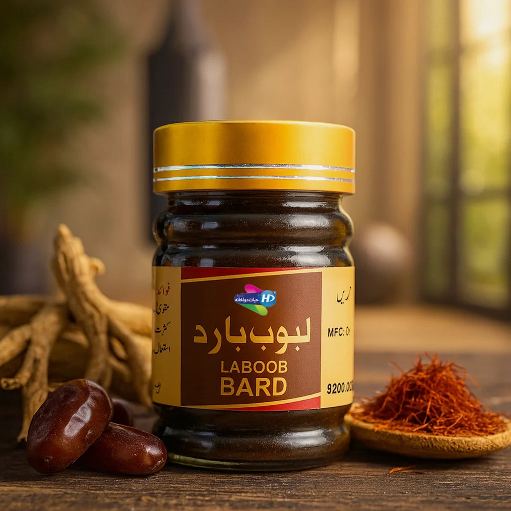 Laboob Bard jar displayed on a wooden surface with dates, ginseng roots, saffron, and herbal ingredients in a warm natural setting.