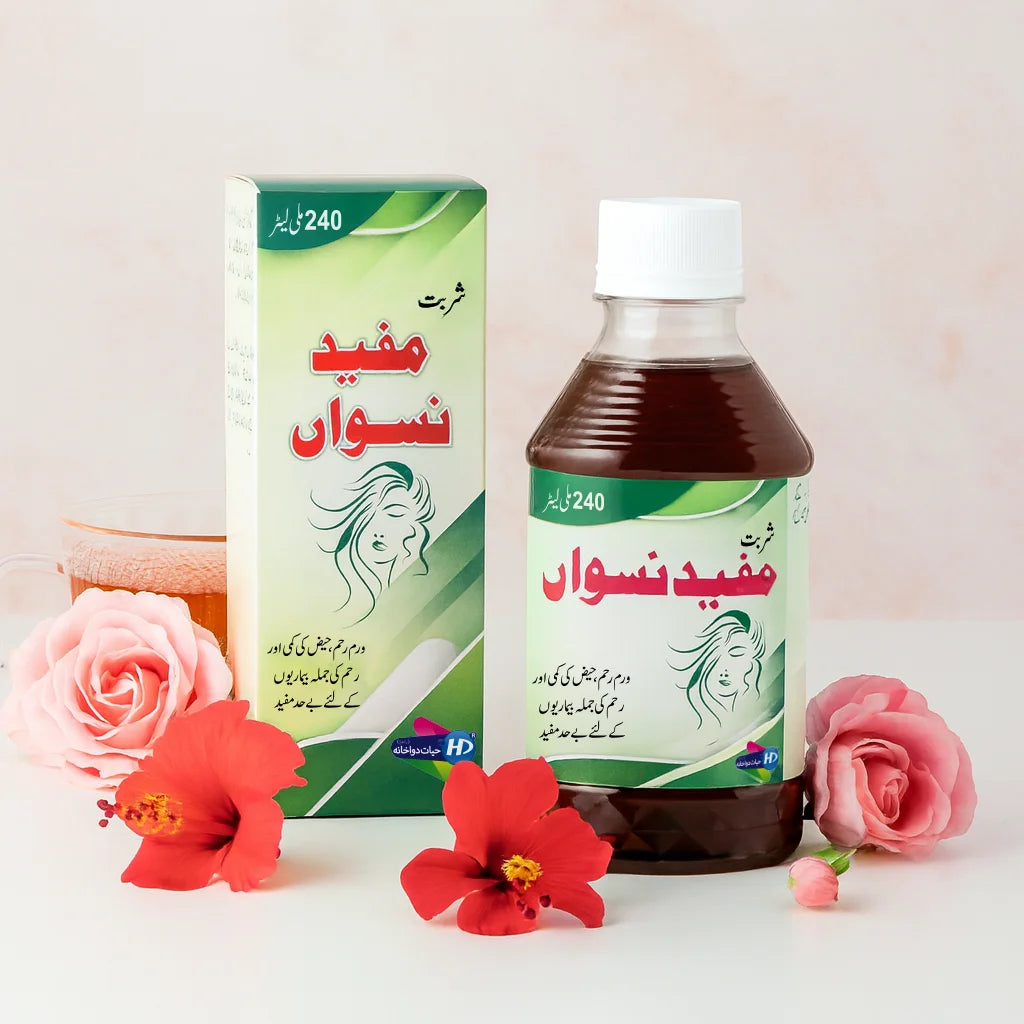 Mufeed e Niswan syrup bottle and box displayed with roses, hibiscus flowers, and a cup of herbal tea.