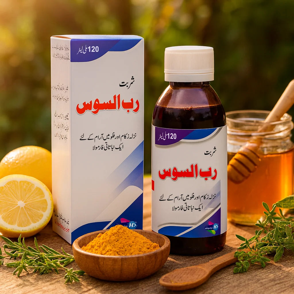 Rub-ul-Sos syrup bottle and box by Hayat Dawakhana placed with lemon, honey, turmeric and herbs in a natural outdoor setting.