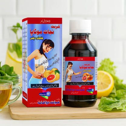 Sharbat Nijat-e-Motapa bottle and box by Hayat Dawakhana with grapefruit, lemon and herbs placed on a wooden table for weight-loss herbal tonic.
