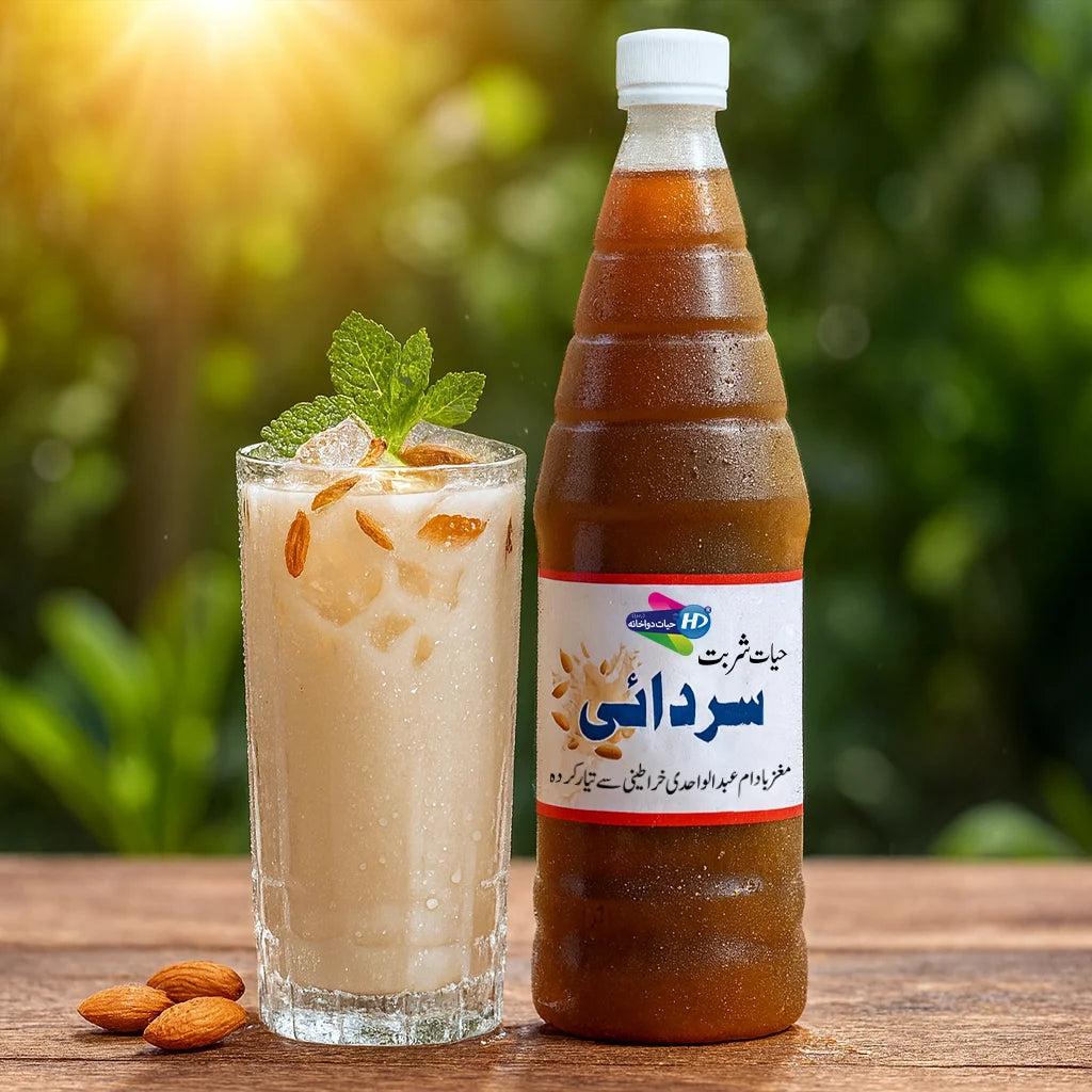 Sharbat Sardai bottle with a creamy iced almond drink topped with almonds and mint placed on a wooden table with green nature background.