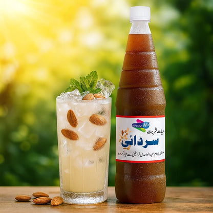 Sharbat Sardai bottle with a chilled almond milk drink garnished with almonds and mint on a wooden surface in sunny outdoor setting.