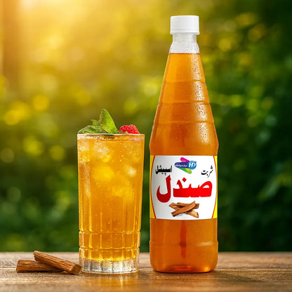 Sharbat Sandal bottle with a glass of chilled sandal drink garnished with mint and a berry on a wooden table outdoors.